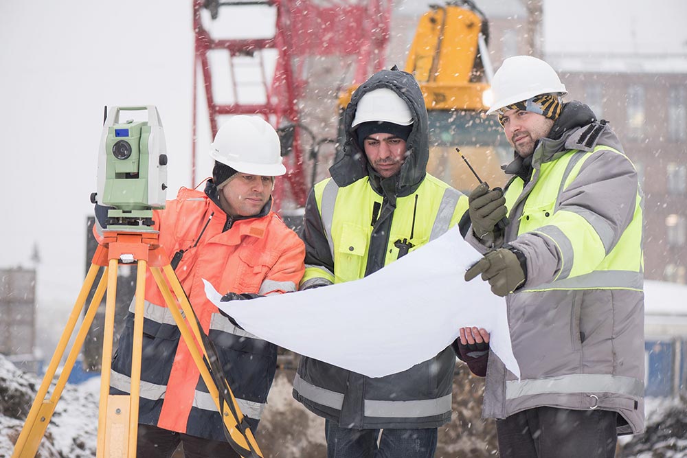 Illustration de 3 hommes sur un chantier de construction en hiver - © Istock 